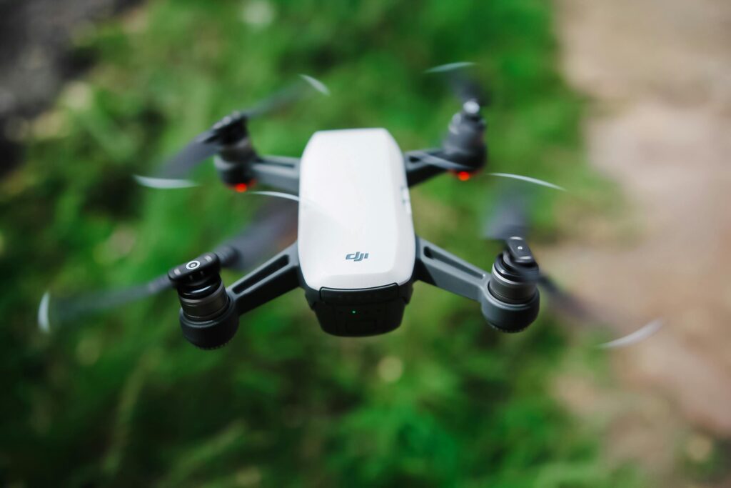 A high-quality image of a drone flying over blurred green grass, showcasing modern technology.